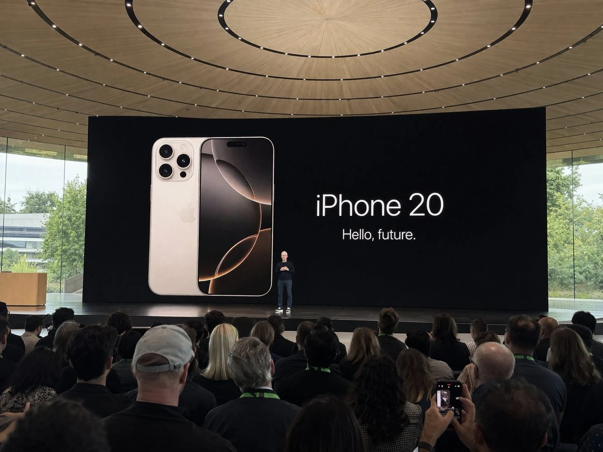 A speaker stands in front of a large screen displaying the iPhone 20 and the text 'Hello, future'.