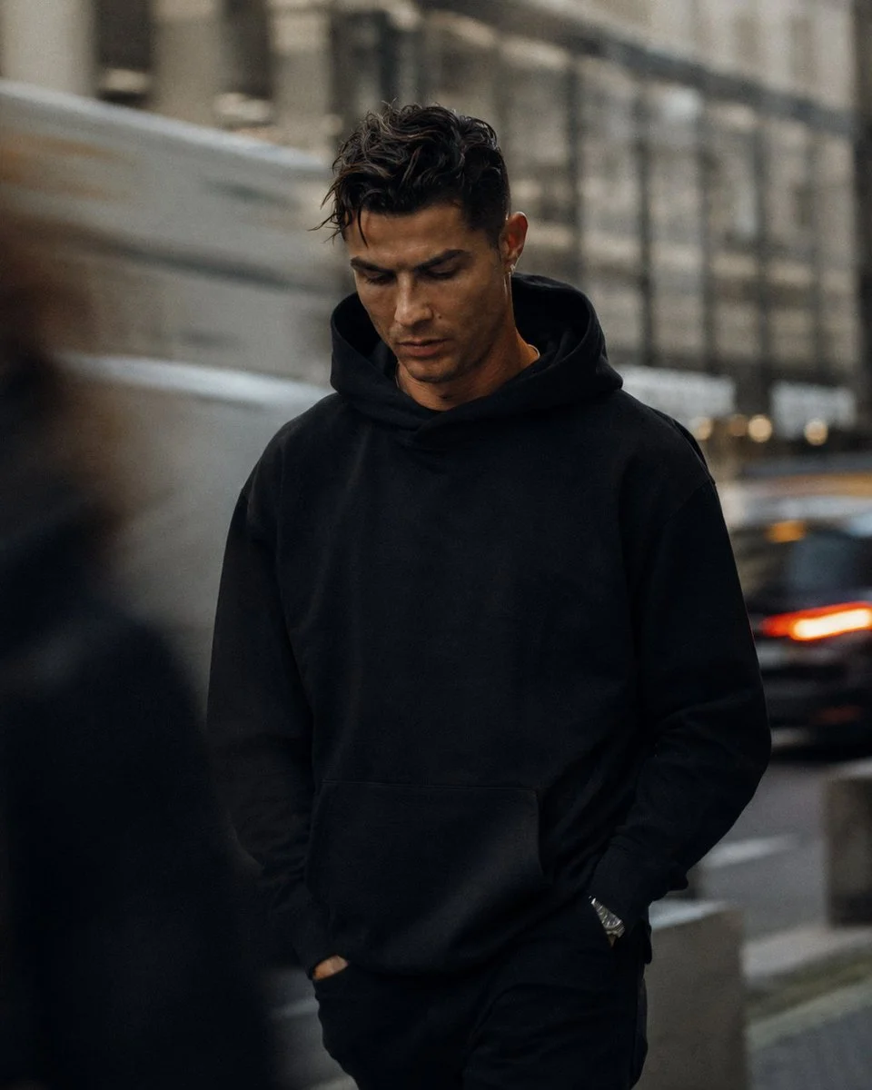 A cinematic street-fashion portrait of a handsome man in oversized clothing, with documentary realism and urban daylight atmosphere