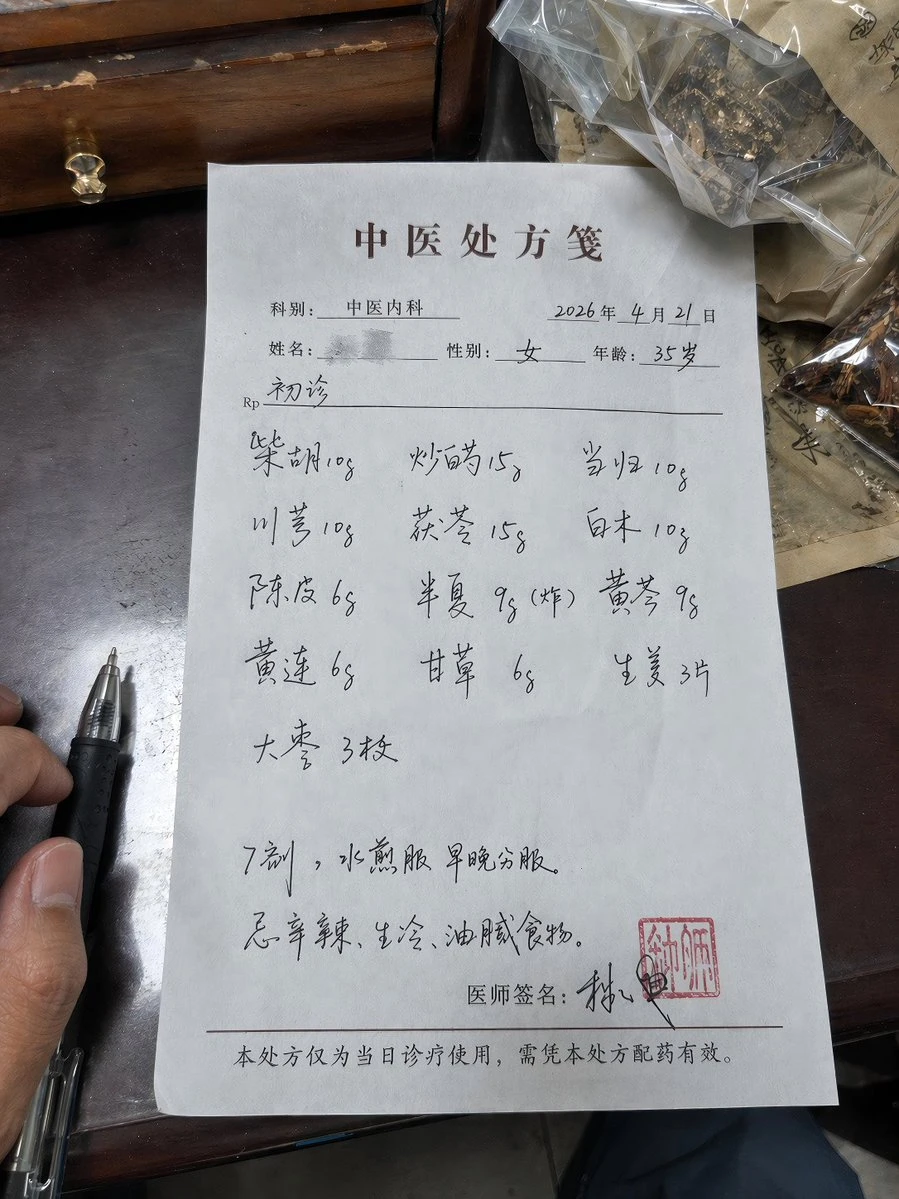 A handwritten medical prescription sheet features Chinese herbal ingredients and dosage instructions, with a pen resting beside it